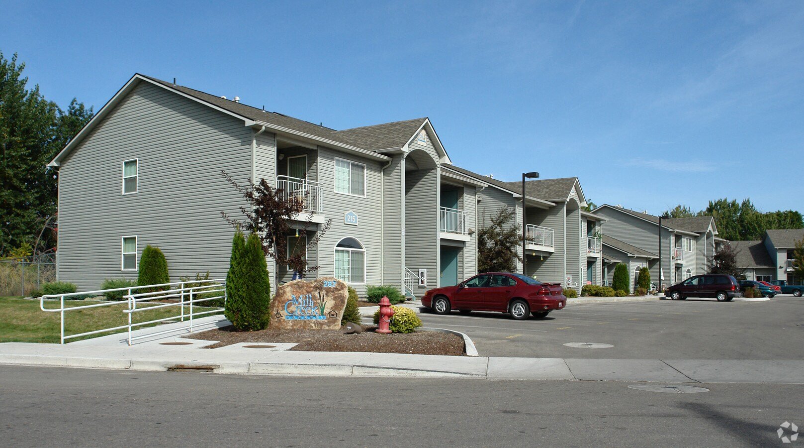 a large apartment complex with a red car parked in front of it